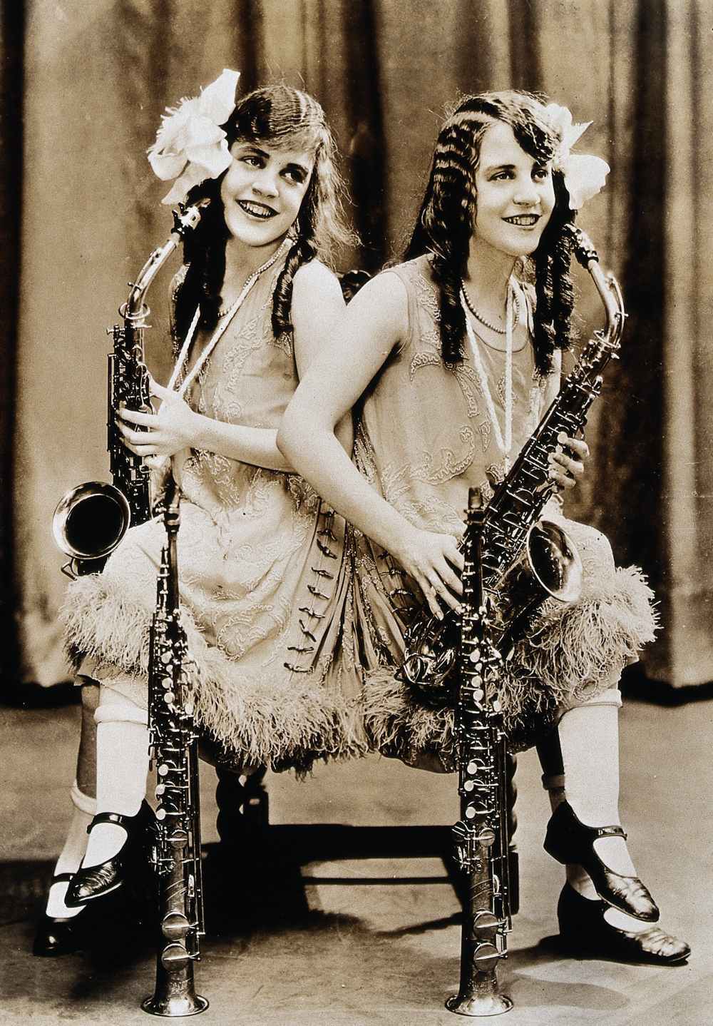 Daisy and Violet Hilton, conjoined twins, with saxophones