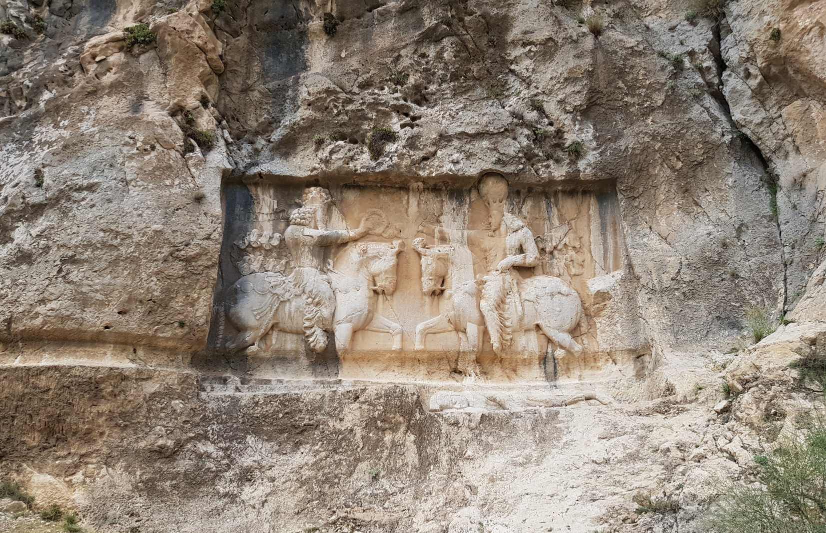 Una antiga talla en baix relleu que representa la victòria del rei sasànida Sapur I sobre l'emperador romà Valerià al c. 260 CE. Aquest baix relleu de Shapur es troba a Bishapur. Vuit jaciments arqueològics que conformen el conjunt estan repartits per tres regions geogràfiques: Firuzabad, Sarvestan i Darab, a la província de Fars.