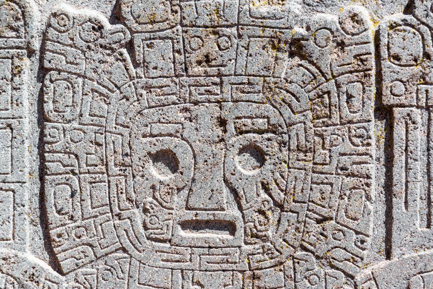Bog prehodov: Pogled od blizu na obraz, ki je rezbaril na ruševinah Tiwanaku v bližini La Paza v Boliviji. Zdi se nesporno, da so umetniki Tiwanaku na svojega boga prehoda gledali kot na ribo (simboli rib so povsod) morda v smislu bitja, ki diha v čeladi, napolnjeni z vodo. Arheologi boga prehodov imenujejo "jokajočega" boga, vendar namesto solz verjetno gledajo v mehurčke. © Avtorstvo slike: Jesse Kraft | Z licenco DreamsTime.com (Založniška fotografija za uredniško/komercialno uporabo, ID: 43888047)