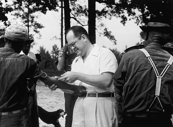 Een slachtoffer van het Tuskegee syfilis-experiment laat zijn bloed afnemen door Dr. John Charles Cutler. C. 1953 © Image Credit: Wikimedia Commons