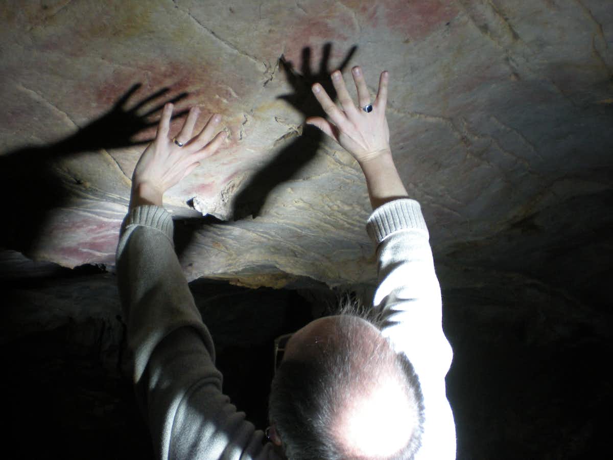 Dans de nombreux cas, des pochoirs de mains ont été laissés sur des parties des murs et des plafonds de grottes difficiles d'accès, comme ceux de la grotte d'El Castillo, Paul Pettitt montrant la position des mains.