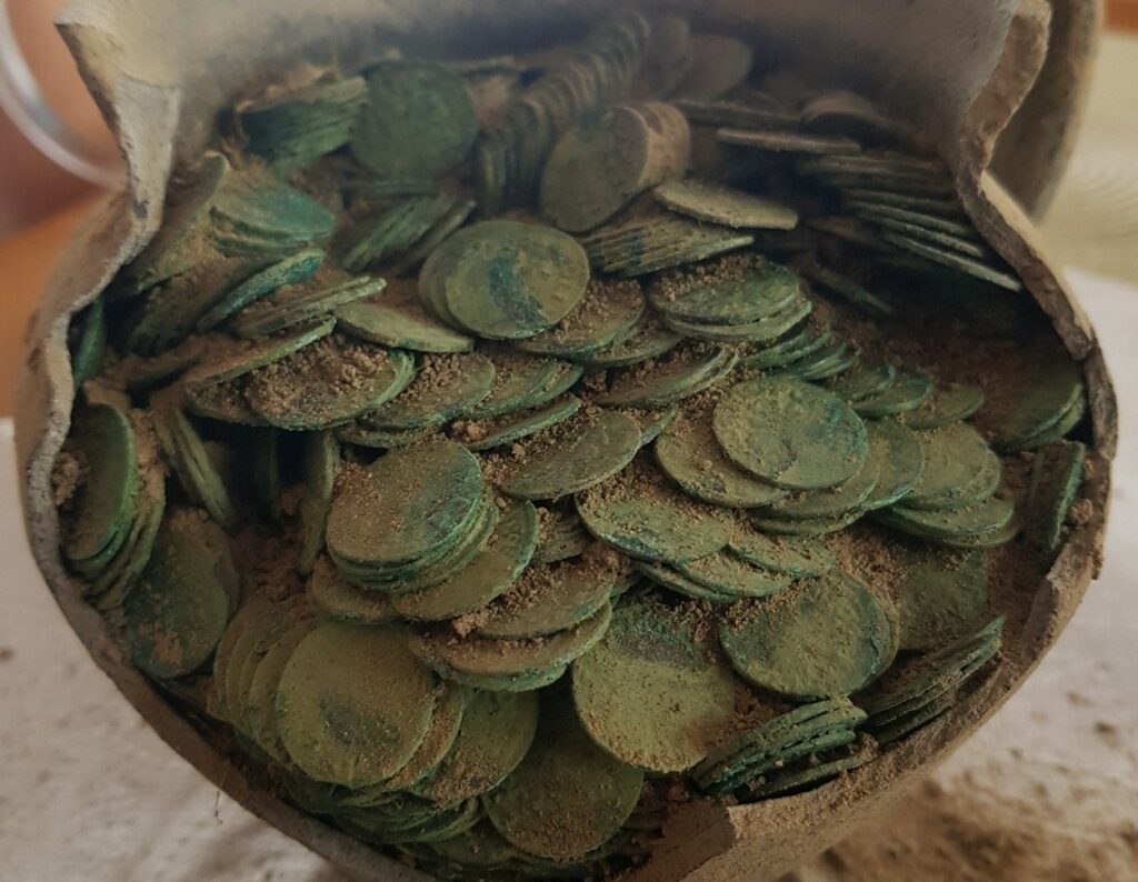 Les archéologues pensent que la cruche d'argile contenant la horde de pièces de monnaie a été délibérément enterrée dans une ferme à l'est de la Pologne dans la seconde moitié du XVIIe siècle.