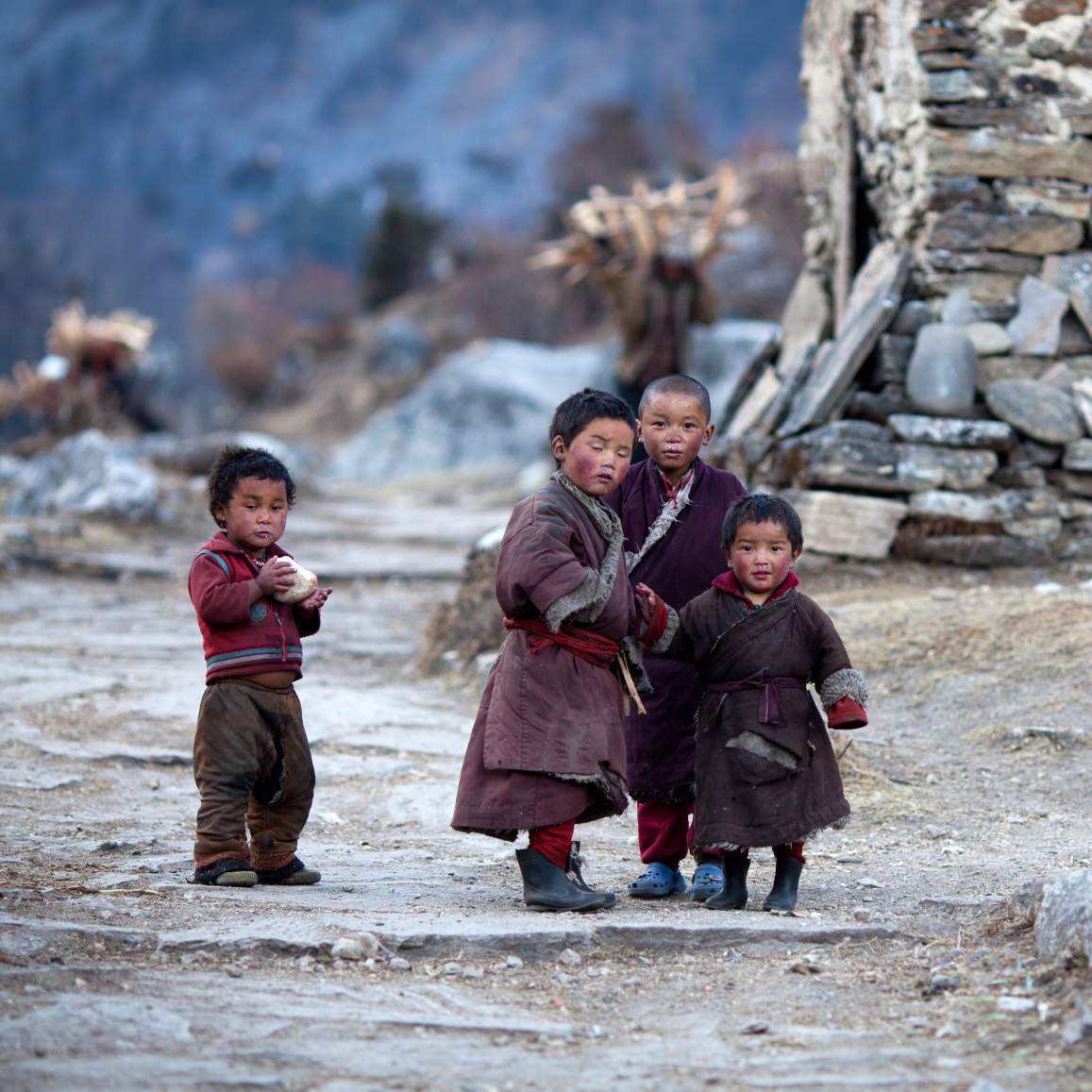Vier etnische Tibetaanse kinderen poseren voor een foto terwijl ze spelen in een Tibetaans dorp.