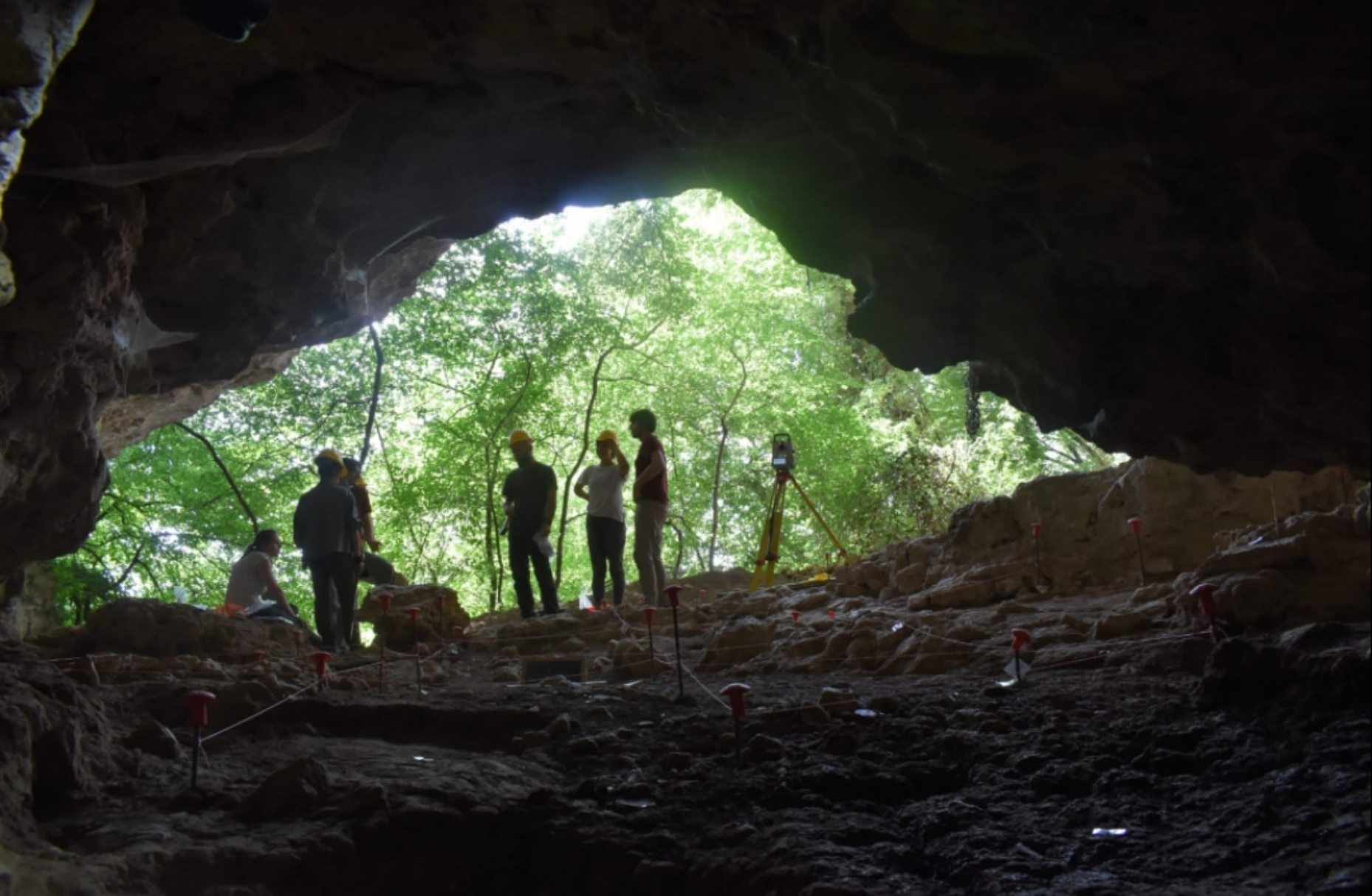 Researchers standing at the mouth of Battifratta Cave, where the 7,000-year-old clay female figurine was discovered.