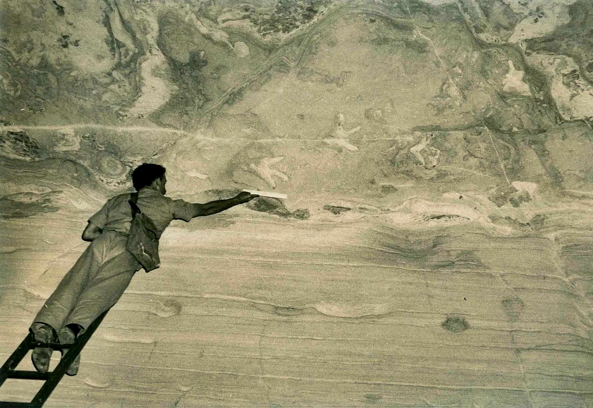 Ross Staines mesurant les empreintes à 4.5 mètres au-dessus du sol de la grotte (vers 1954).