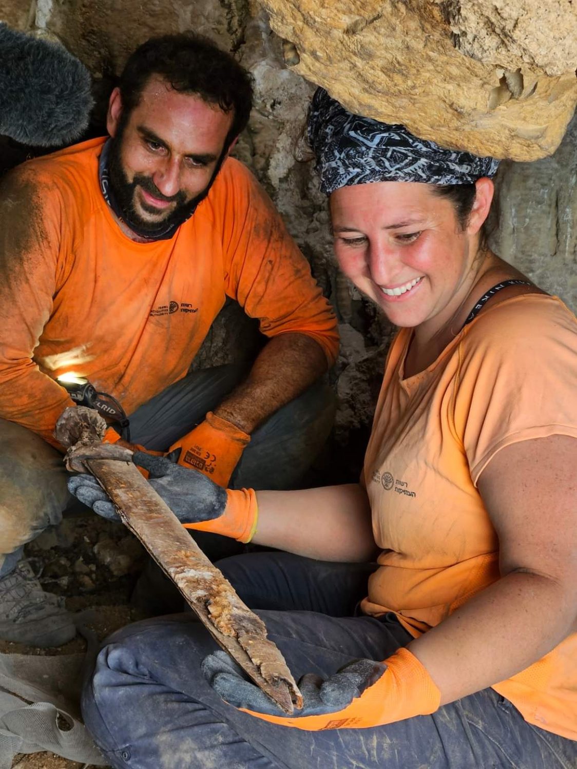 Archeologen Oriya Amichay en Hagay Hamer verwijderen een van de Romeinse zwaarden uit de spleet waar ze verborgen waren.